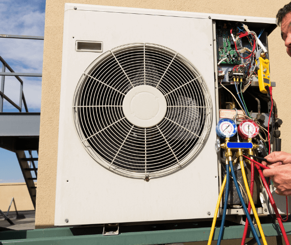A white air conditioner sitting outside of a building.